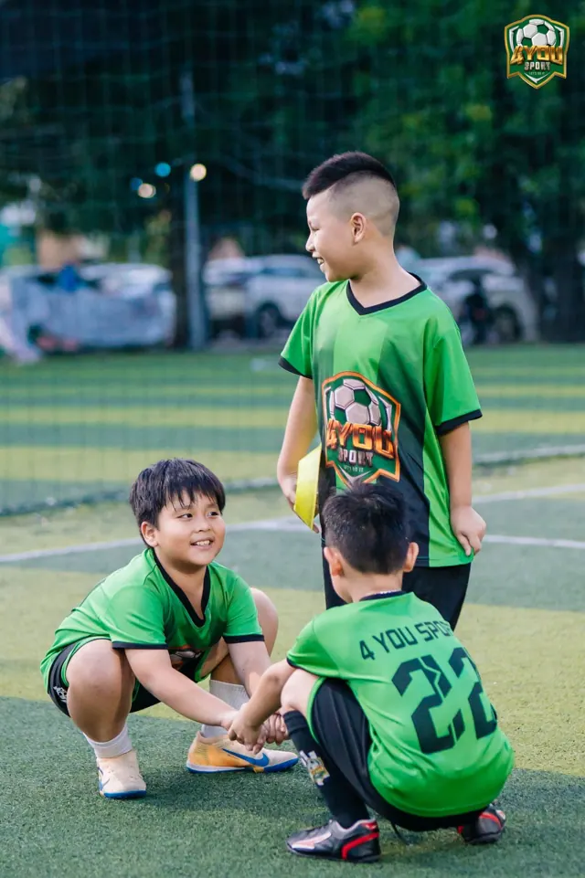 Hai học viên nhí cười tươi trên sân