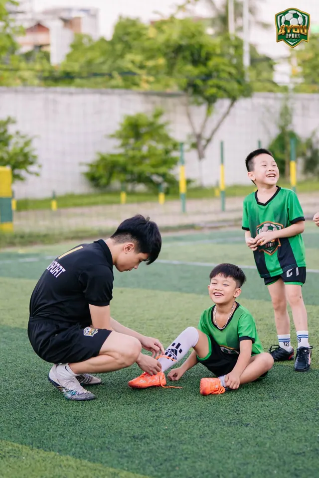 Thầy buộc lại dây giày cho bé