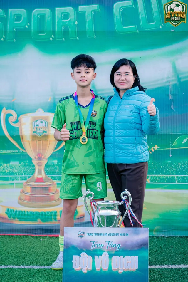 Mẹ chụp ảnh cùng con nhận huy chương tại lễ bế mạc