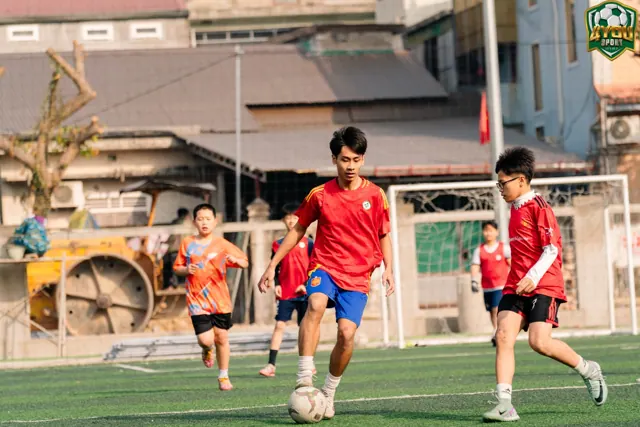 Học viên lớn đua dẫn bóng tốc độ trên sân cỏ nhân tạo